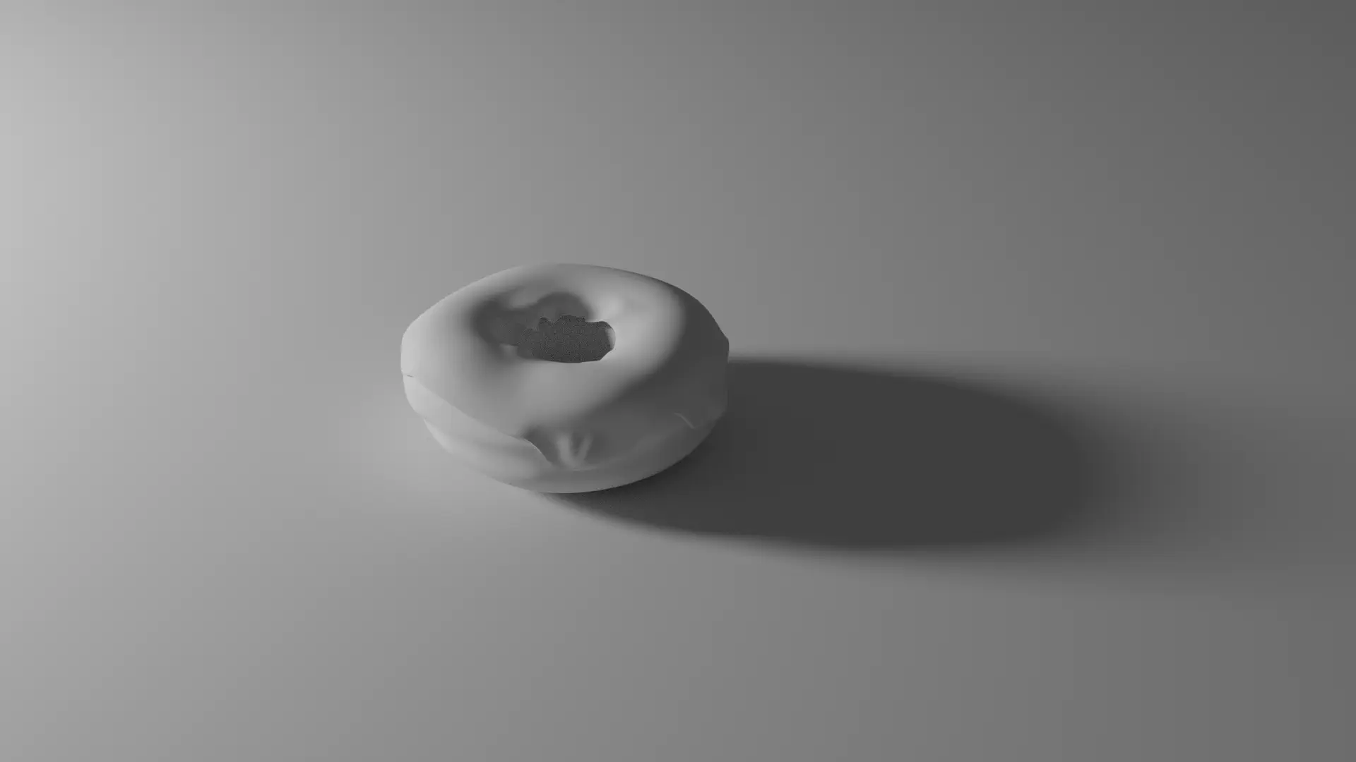 A 3D render of a donut with no materials on the floor being illuminated from the left side of the donut.